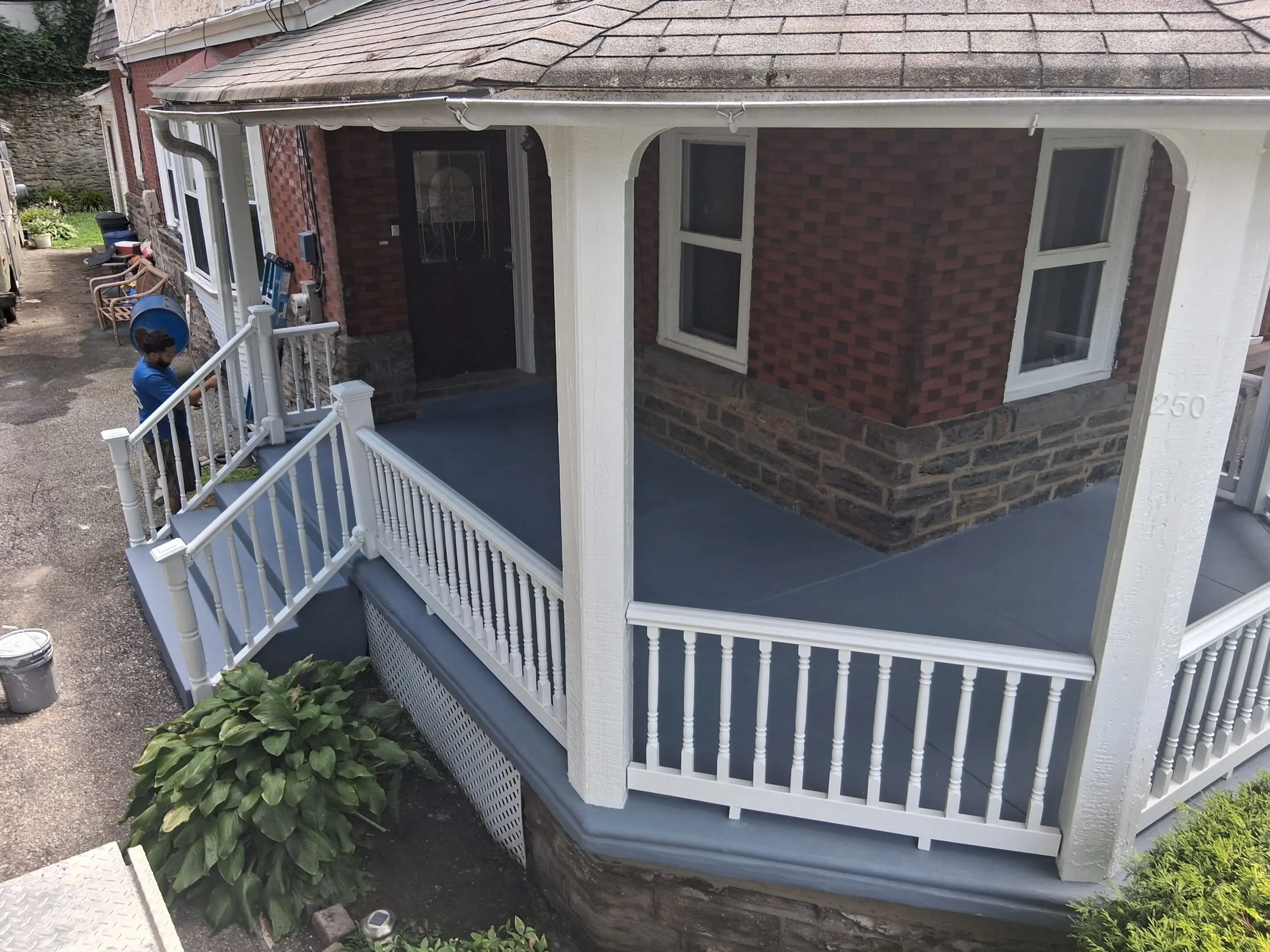 Freshly painted porch with white railing and blue floor.