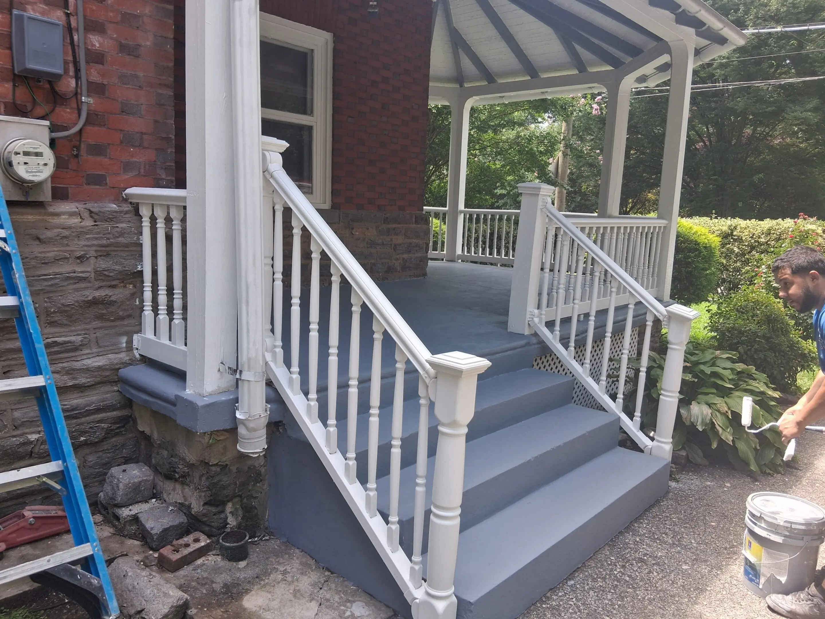 Newly painted gray stairs with white railings on a porch.