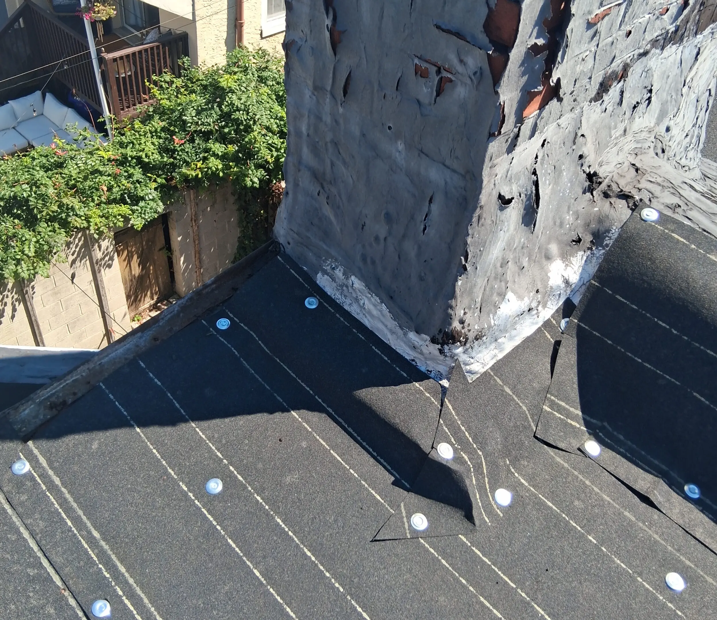 Close-up of a rooftop corner with waterproofing membrane installation.
