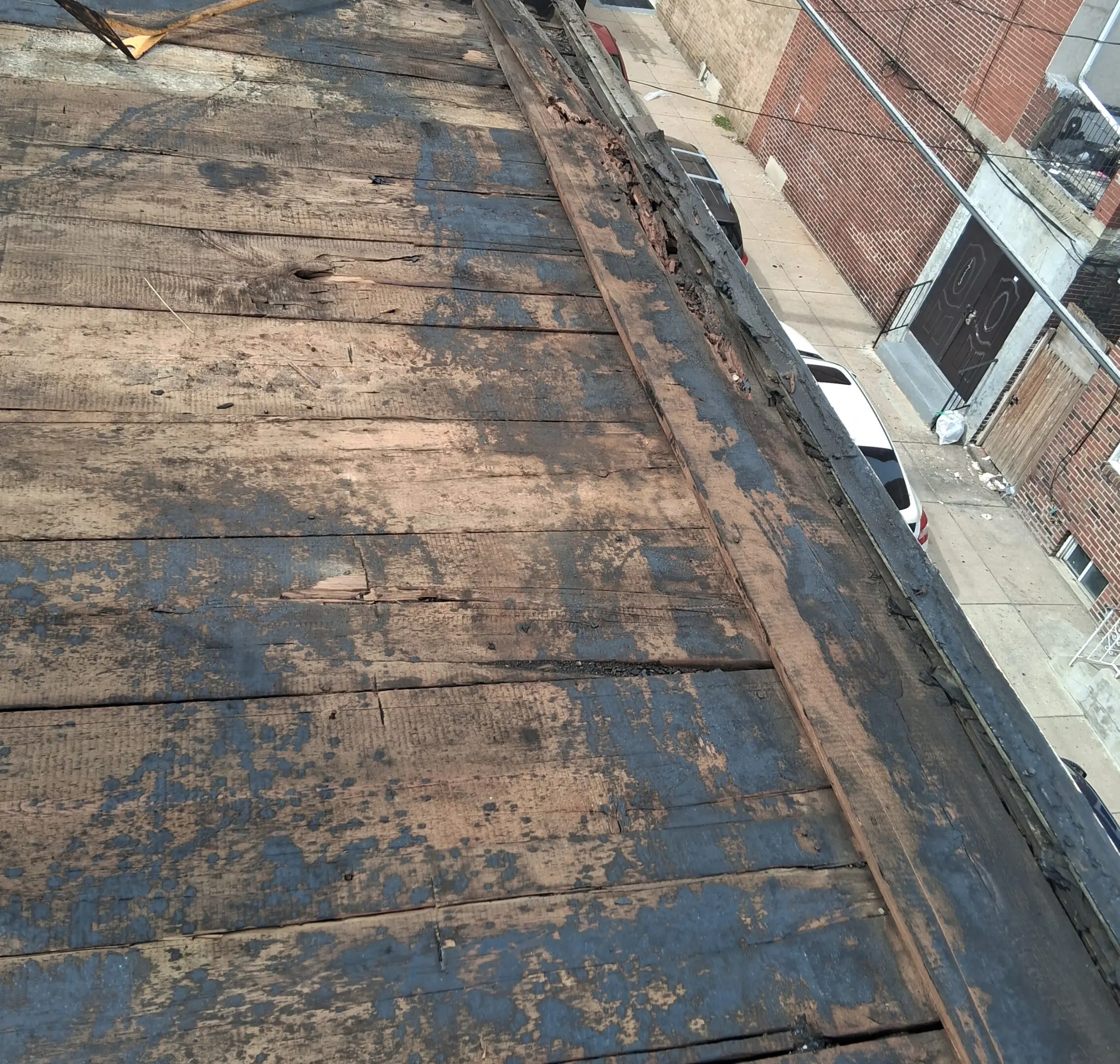 Old, worn-out roof with patches and visible damage.