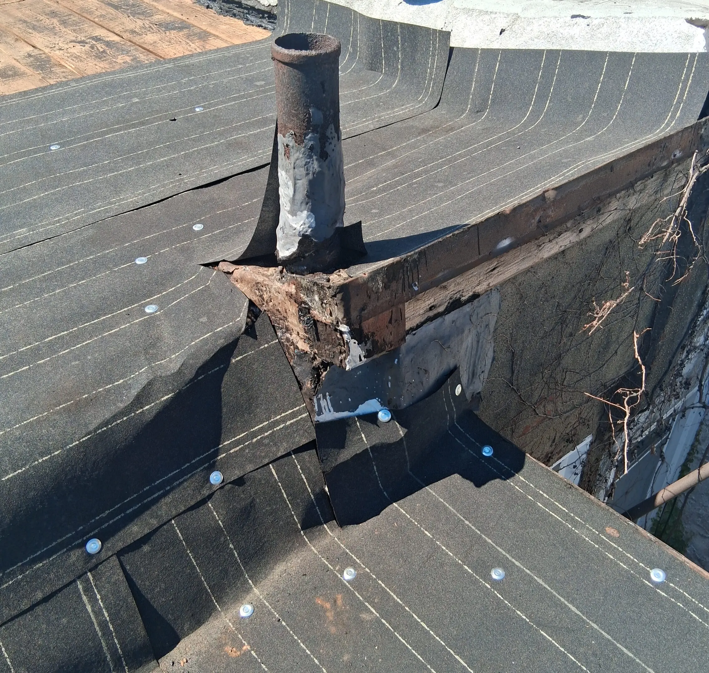 Damaged roof flashing with visible rust and deterioration.