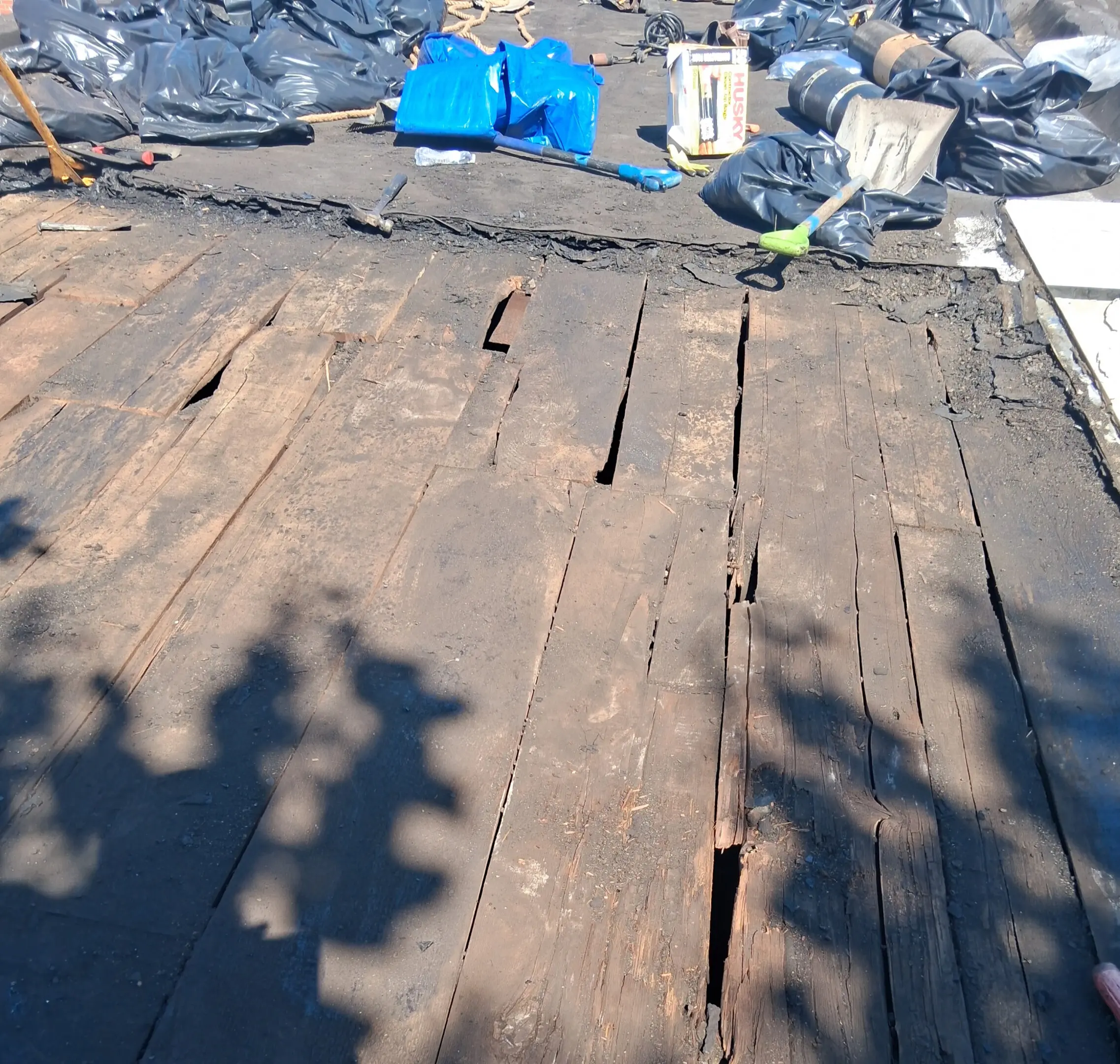 Weathered wooden planks with shadows cast on them outdoors.