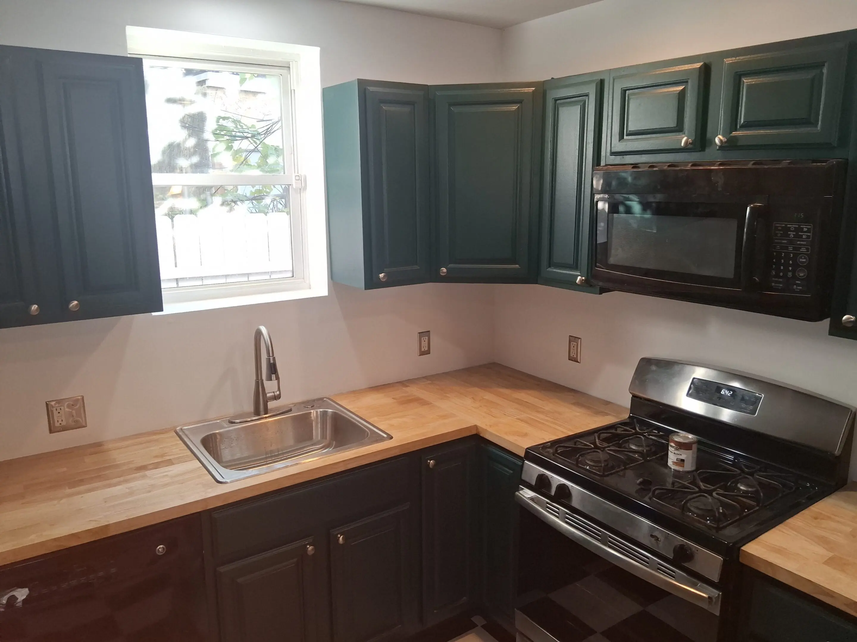 Modern kitchen with dark cabinets and stainless steel appliances.