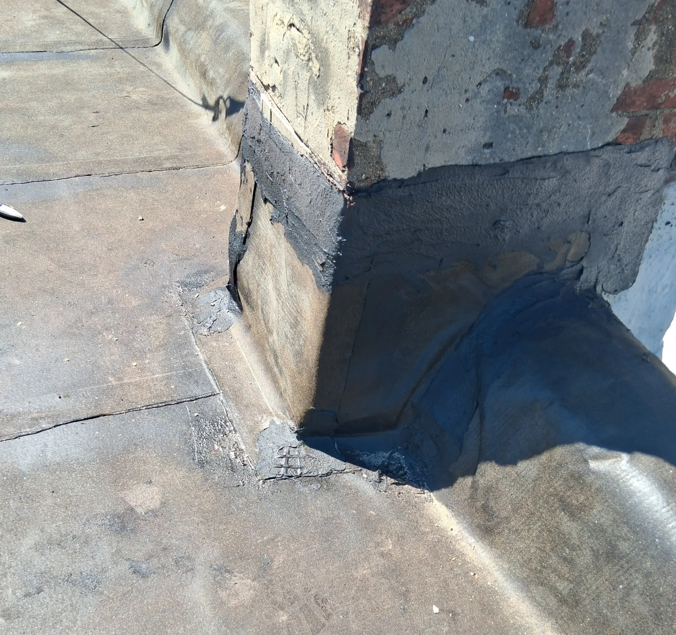 Concrete pillar base with visible cracks and patch repairs.
