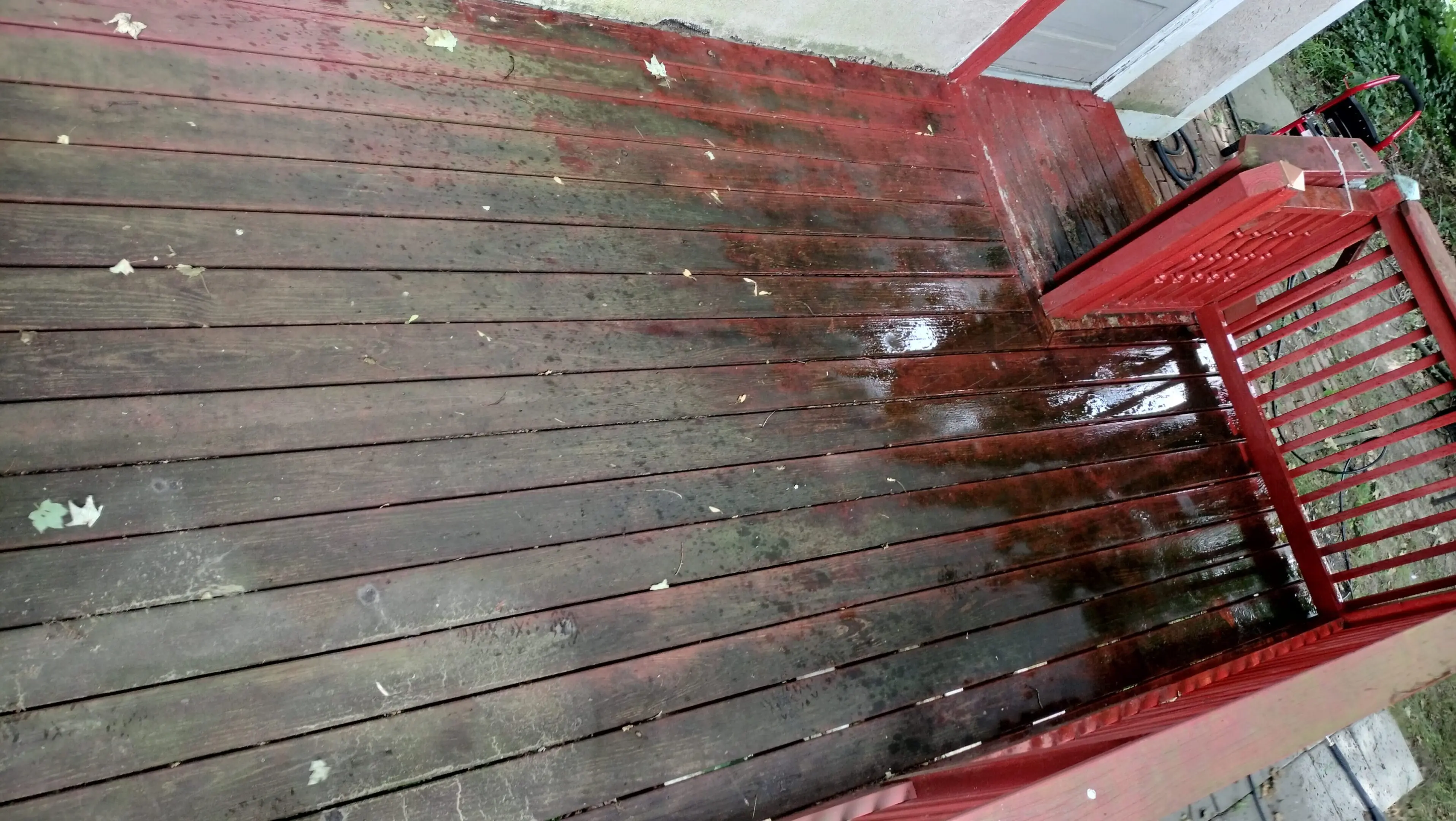 Red and brown wooden floor with visible wear and water stains.